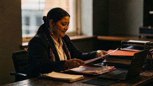 Administrator reviewing board documents at a desk